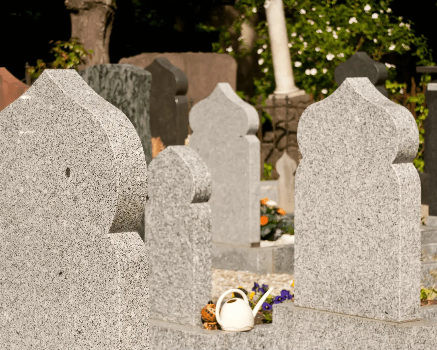 Stèles funéraires en granit de forme orientale dans un carré musulman de cimetière.