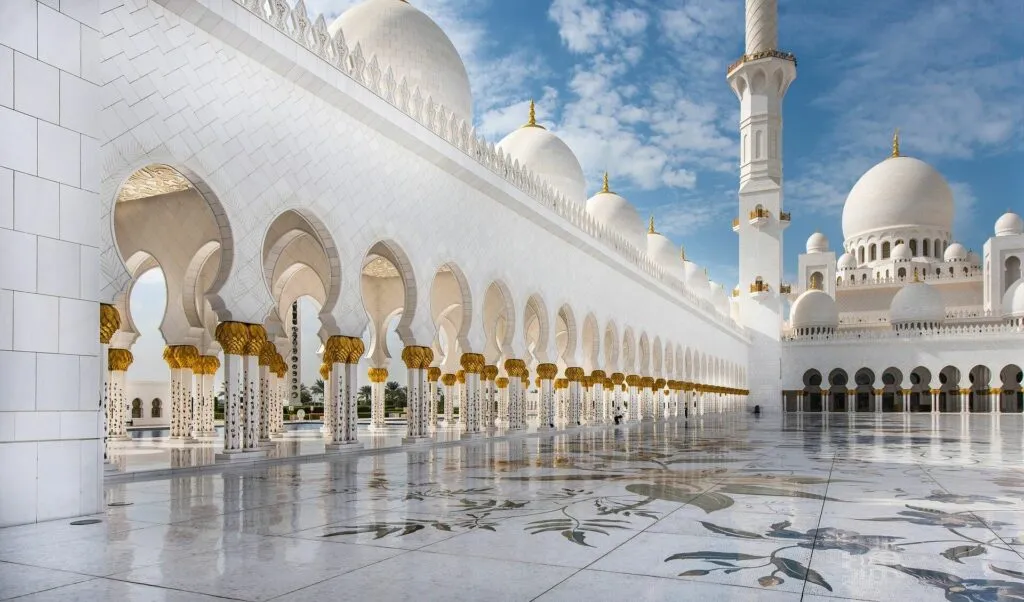 Vue ensoleillée des arcades et des dômes en marbre blanc de la Grande Mosquée Cheikh Zayed